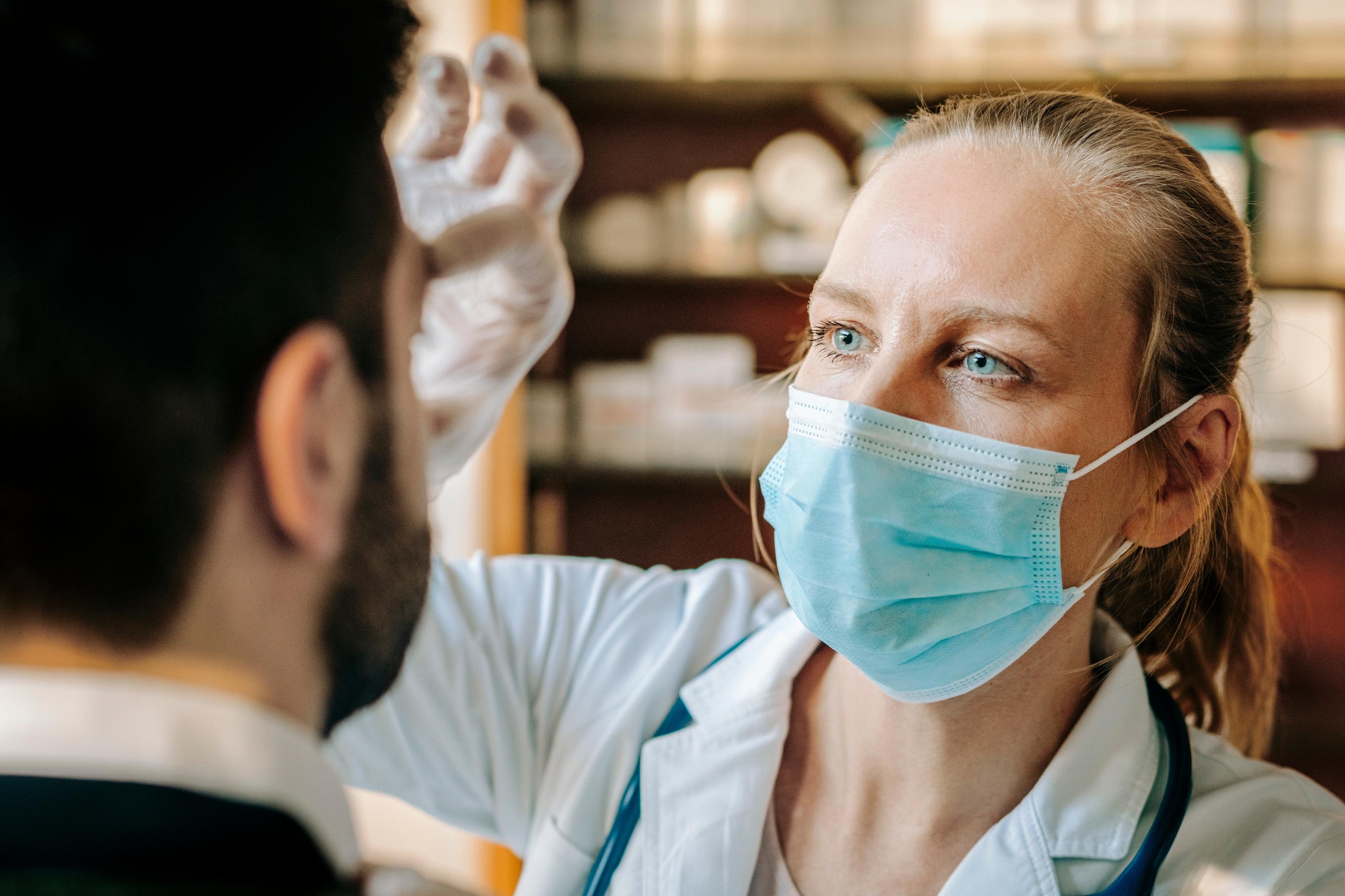 A close up of a Caucasian male surgeon scrubbing his hands with soap at a scrub sink in preparation for a surgical procedure.