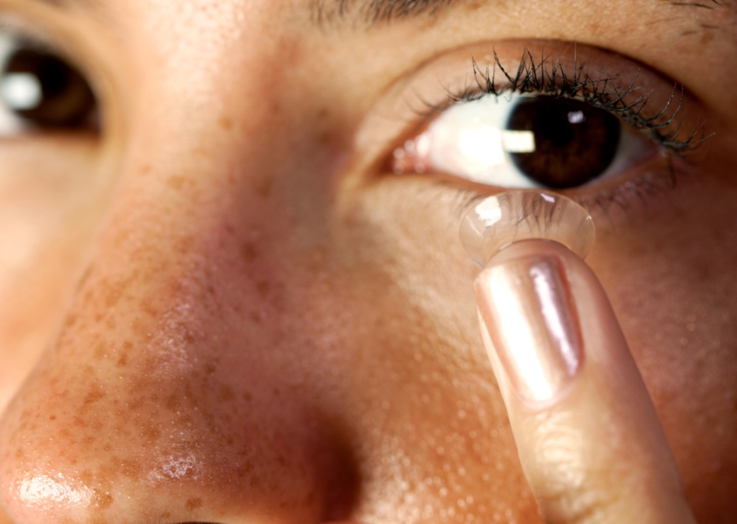 Woman putting in contact lenses